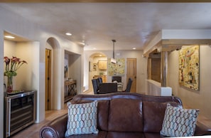 Living/dining area with Kitchen through arched doorway in background