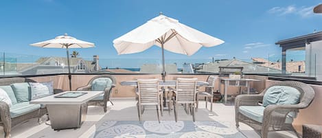 The rooftop deck includes ample seating, a large dining area, market umbrellas, propane gas BBQ grill, and ocean view make this the perfect hangout spot.