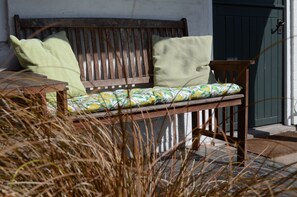 Covered seating area by the cottage door