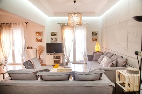 Spacious living-room with comfortable sofas and handmade furniture