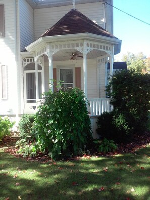 Turret porch offers a quiet spot to relax. Shaded by a 120 year old tree