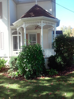 Turret porch offers a quiet spot to relax. Shaded by a 120 year old tree