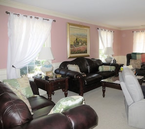 Living room contains couch, loveseat and 3 chairs.