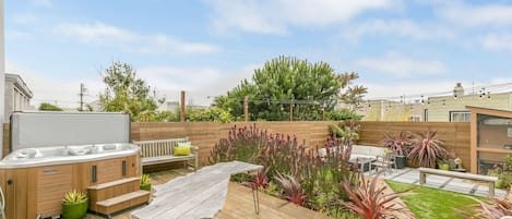 Large backyard with fire pit, hot tub, and multiple seating areas