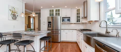 Updated kitchen with Quartz countertops, Corian backsplashes and SS appliances