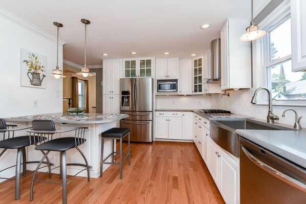 Updated kitchen with Quartz countertops, Corian backsplashes and SS appliances
