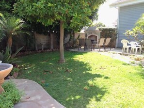 Backyard with water fountain, fireplace and picnic table.