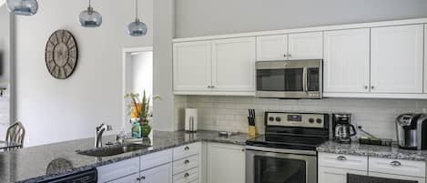 Beaming white cabinetry; Stainless steel appliances