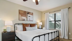 King bedroom with luxury hotel quality linens, twin trundle bed, and balcony with a view