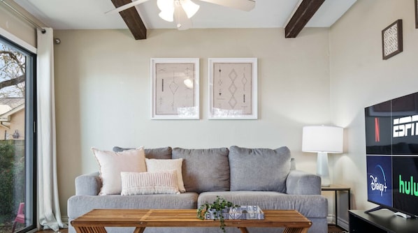 Living room with queen sleeper sofa, smart tv, patio access, and fireplace