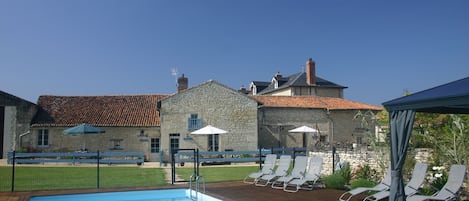 Enclosed swimming pool area with 3 gites beyond