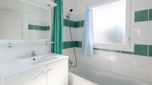 This bathroom features a shower and tub combination.