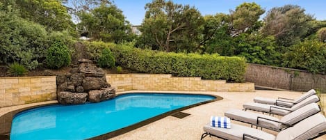 Breathtaking solar-heated pool, complete with elegant landscaping, and ample seating