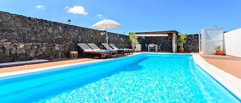 foto principal,piscina rodeada con muros de piedra volcanica para mayor intimida