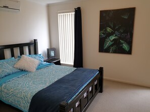 Master bedroom with air-con, dresser with mirror and walk-in closet