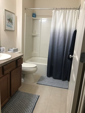 Hall bathroom with large shower, fresh towels and hair dryer.