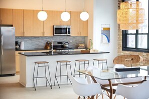 Kitchen wth large island, granite countertops and stainless appliances