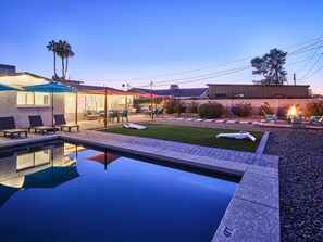 Private backyard with a pool, fire pit, corn hole, sun loungers, BBQ grill, and multiple seating areas.