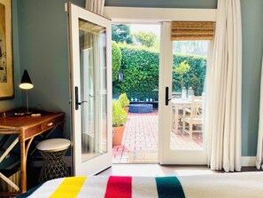 French doors in primary bedroom adjoin back patio