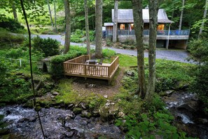 The creek is right next to the cabin - You step out onto the cabin's deck, a steaming mug of coffee warming your hands. Below you, a bold mountain creek rushes by, its gurgling waters a constant, calming presence. This isn't just any background noise – it's the soundtrack to your Smoky Mountain escape.