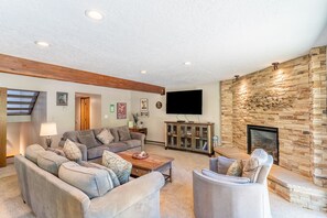 Cozy living area with large mounted flat screen TV, gas fireplace with beautiful stone surround, plenty of seating for your whole group and access to the main balcony.