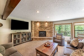 Cozy living area with large mounted flat screen TV, gas fireplace with beautiful stone surround, plenty of seating for your whole group and access to the main balcony.