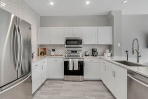 Fully stocked kitchen. Pots, pans, utensils, cups, bowls, cutting boards, knives