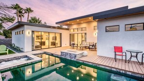 Modern home with patio, pool, and fire pit, set in twilight ambiance.
