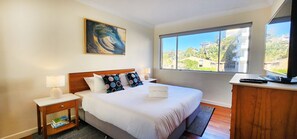 Main bedroom with King sized bed, built-in wardrobes and TV