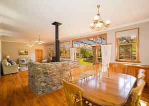 Interior features a large wood burner with stone wall surround.