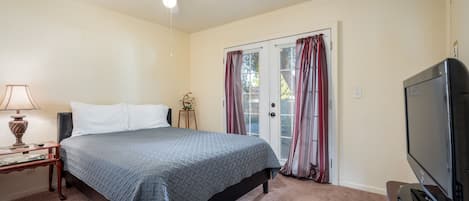 Queen bedroom 1 with French doors to backyard and en suite bathroom