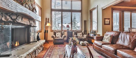 Main Level Living Room with Cozy Mountain Furnishings, Vaulted Ceilings, Warm Gas Fireplace, and Large Windows for Natural Light