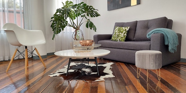 Chic living room with design pieces, antique wood floors & bright artistic vibe