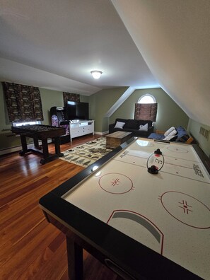 game room above garage with Air hockey, fooseball and an arcade games console 