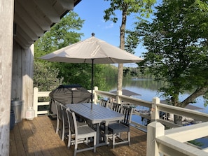 Main level deck just outside living room with table, umbrella & propane grill 