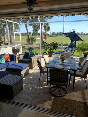 Lanai with dining table, sectional sofa, swing chair and retractable awning