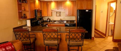 Newly renovated/stocked kitchen with granite countertops and bar seating for 3