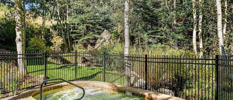 Enjoy the year round hot tub at Interlude nestled in a wooded area of the property.