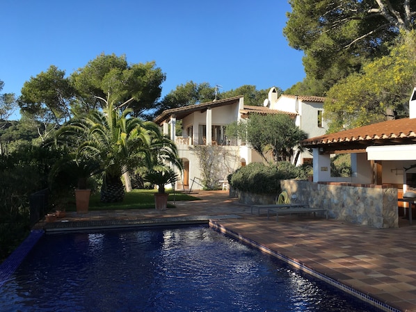 The pool and the pool-house to the right, and the Villa in the background