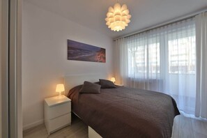 A cozy bedroom with a double bed, bedside table, and soft lighting creating a warm ambiance.