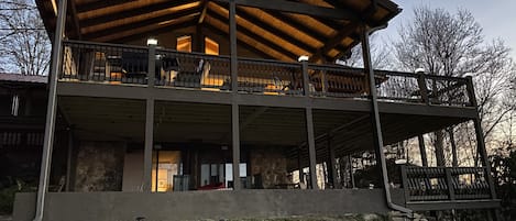 Side of the house showing upper and lower decks at dusk
