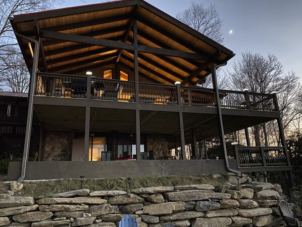 Side of the house showing upper and lower decks at dusk
