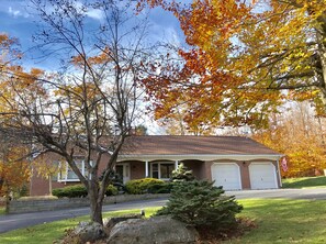 House under a clear blue sky and vibrant autumn foliage, photo unretouched.