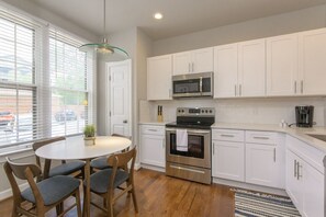 The kitchen also hosts a small table for meals and a pantry closet