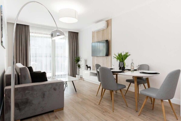 A modern living room with a gray sofa, a small round table, and decor that creates a comfortable atmosphere.
