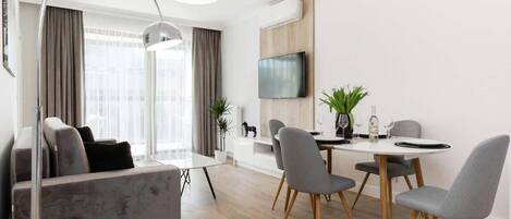 A modern living room with a gray sofa, a small round table, and decor that creates a comfortable atmosphere.