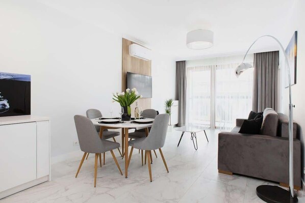 A modern living room with a gray sofa, a small round table, and decor that creates a comfortable atmosphere.