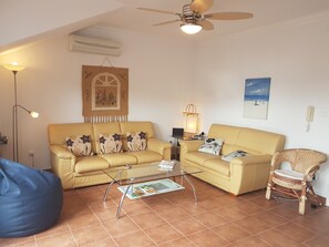 sitting room with leather settees and fan