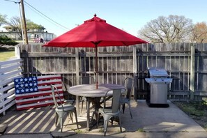 Outside patio area that includes a gas grill. 