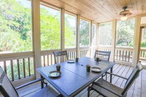 Rue de Buci features a large screened porch with a dining table and ceiling fans.